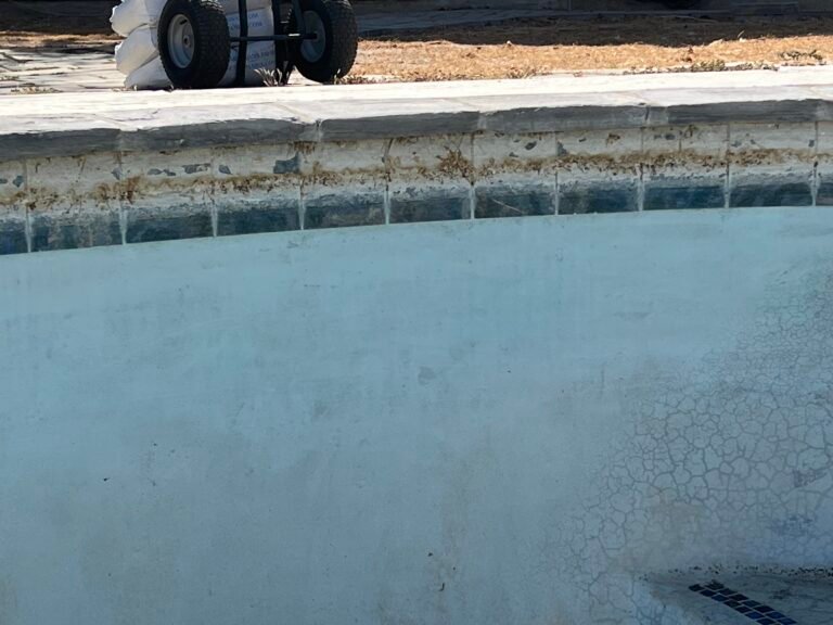 Calcium scale buildup on pool waterline tile in the High Desert